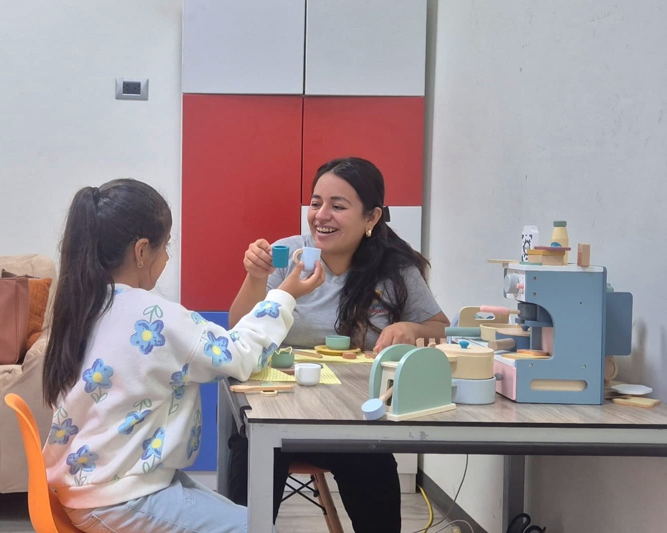 Psicóloga y niña compartiendo un juego de té